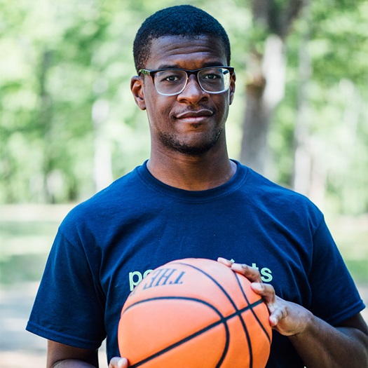 Fabrice Vile posant avec un ballon de basketball