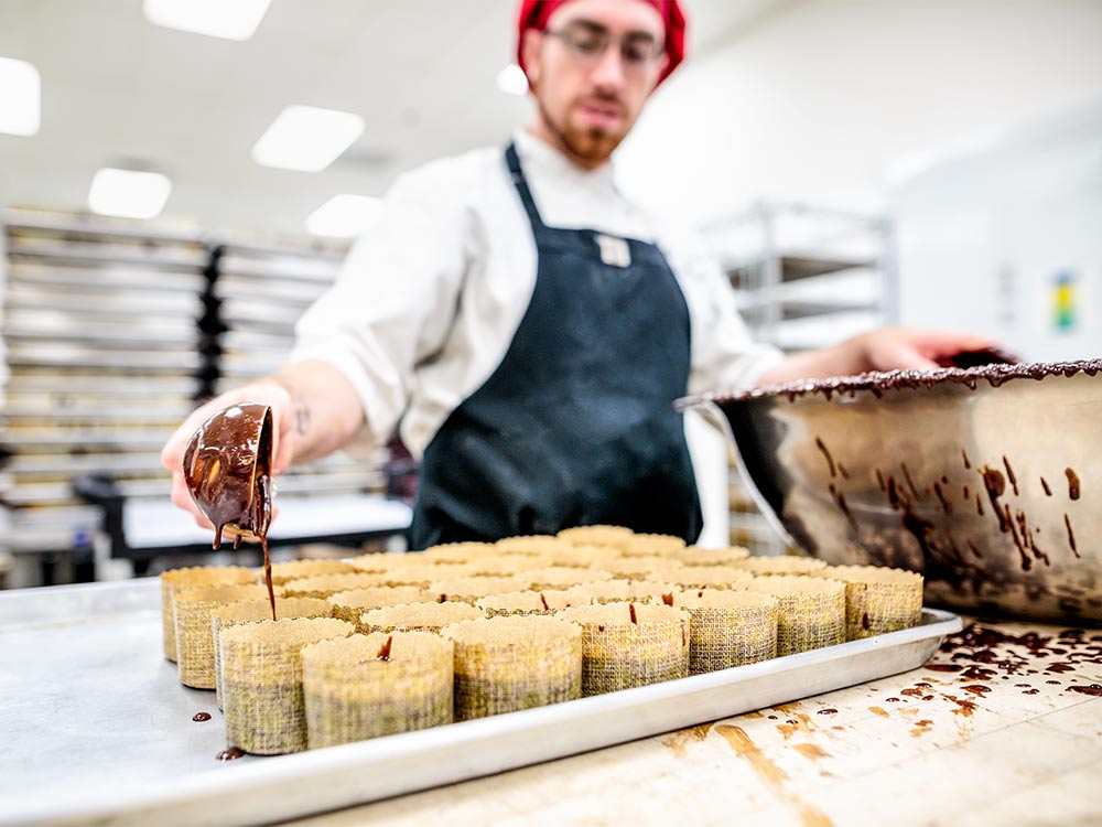 Employé cuisinant des brownies